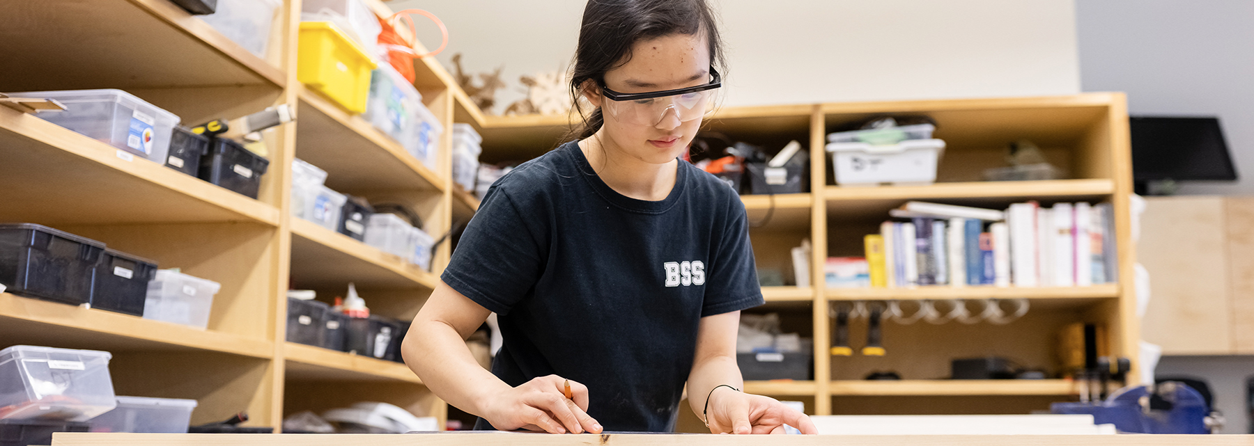 A middle school BSS student works at a drafting table.