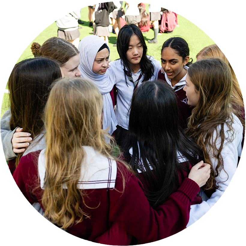 A large group of middle school girls are huddling in the BSS field .