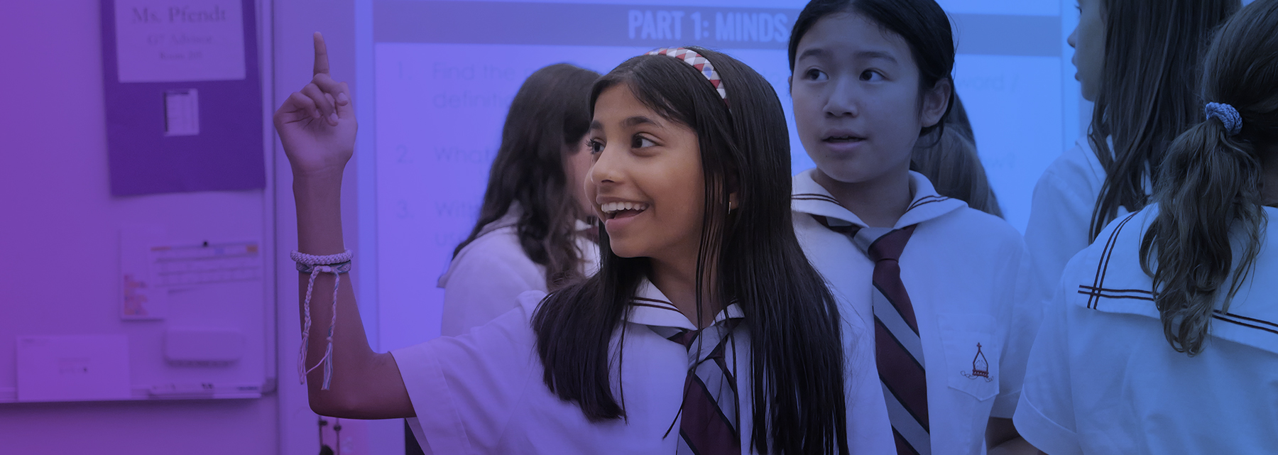 A young junior school student points her finger in the air with an idea.