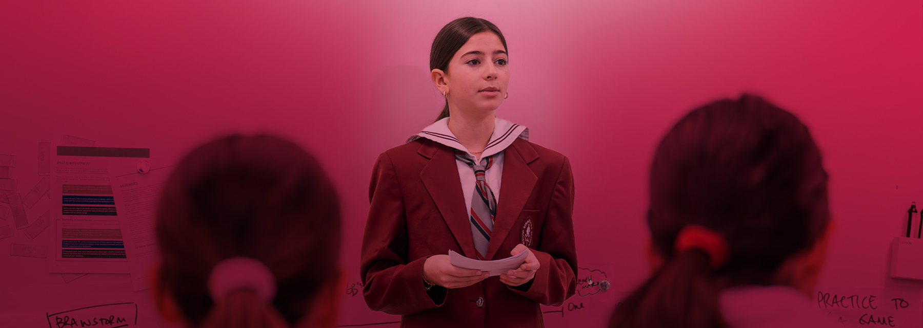 A BSS middle school student stands giving a speech.